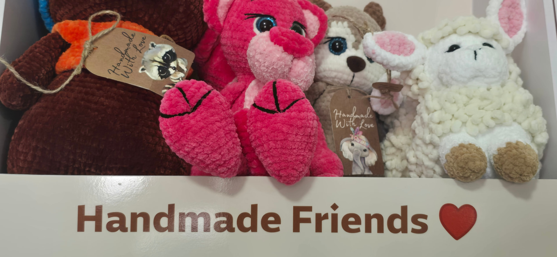 Handmade crochet friends with Handmade With Love tags on a Dana Toys shelf